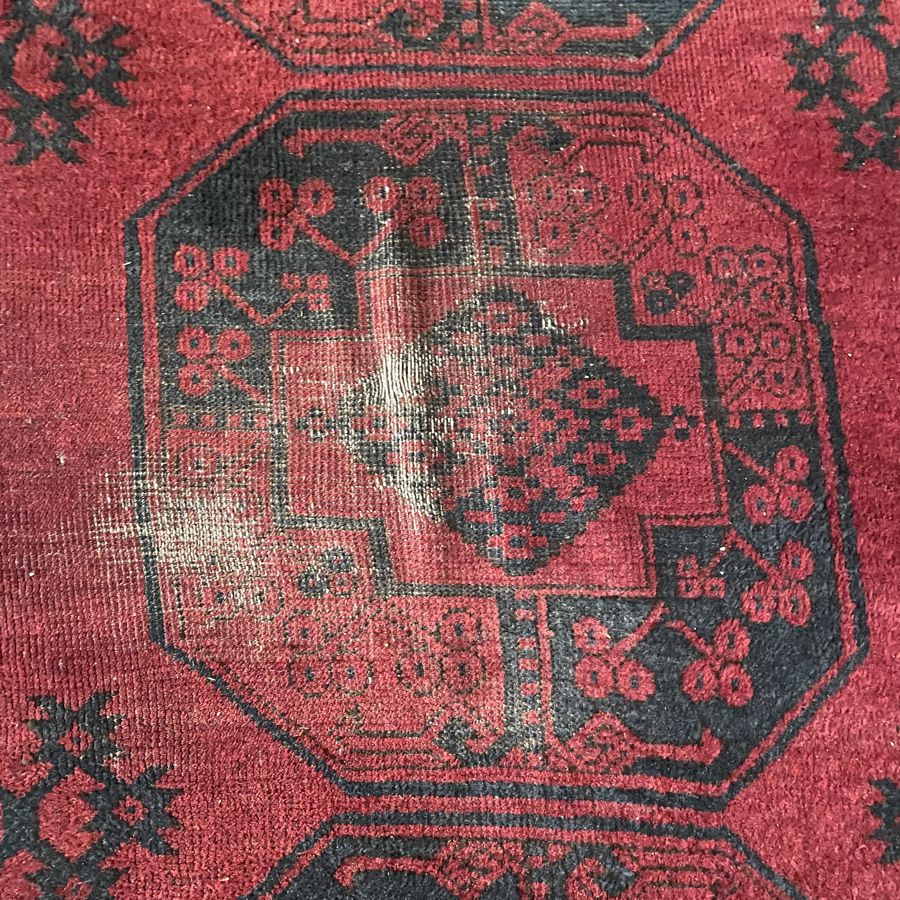 Afghan rug with a worn area in the medallion