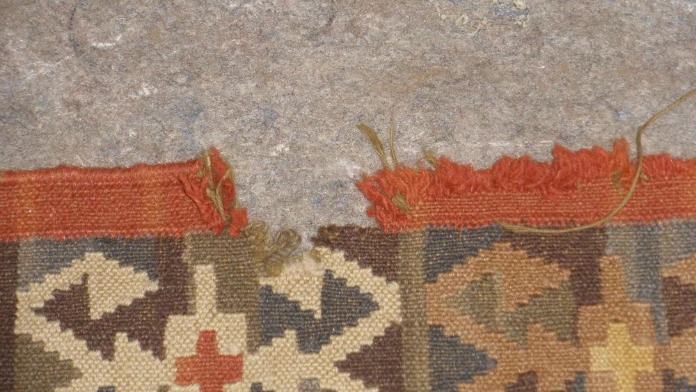 Kilim with a torn, frayed edge