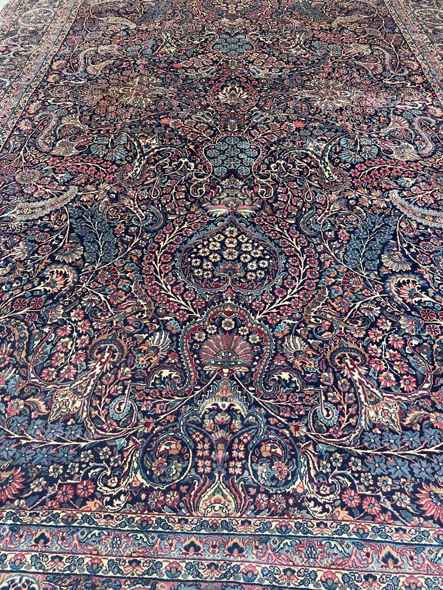 Fine Persian rug with navy field and detailed floral medallion, cleaned by Newport Rugs