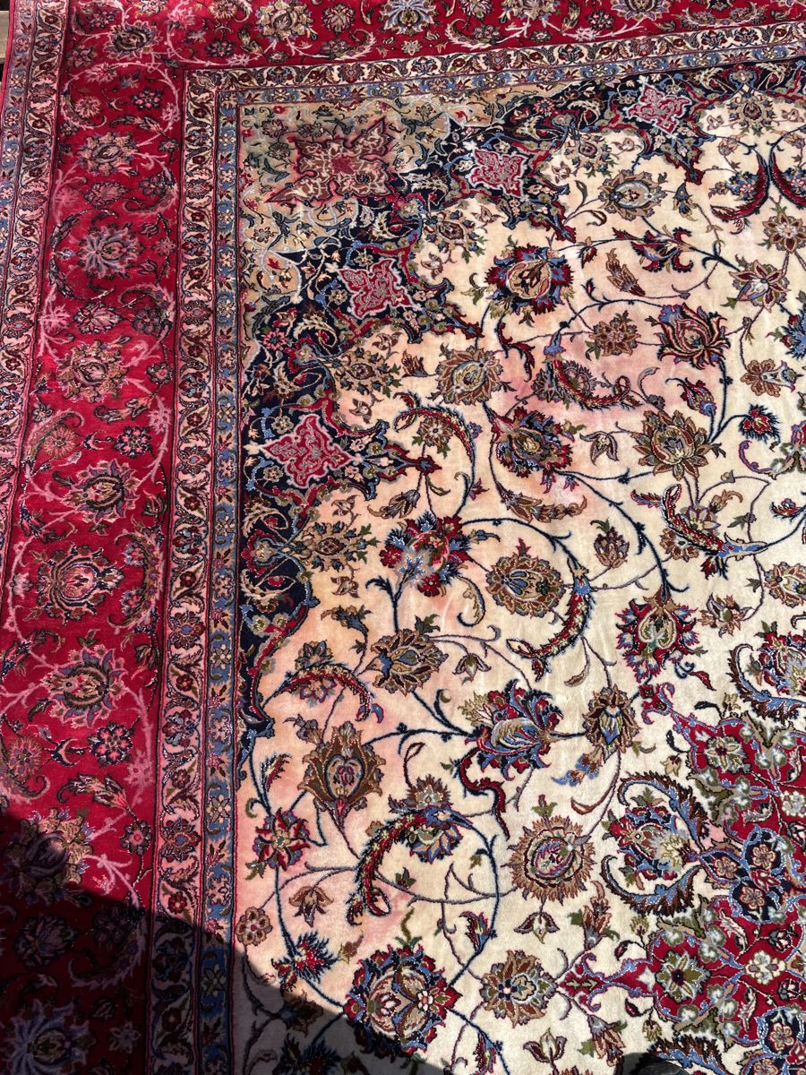 Persian rug with pink dye bleeding into the ivory field